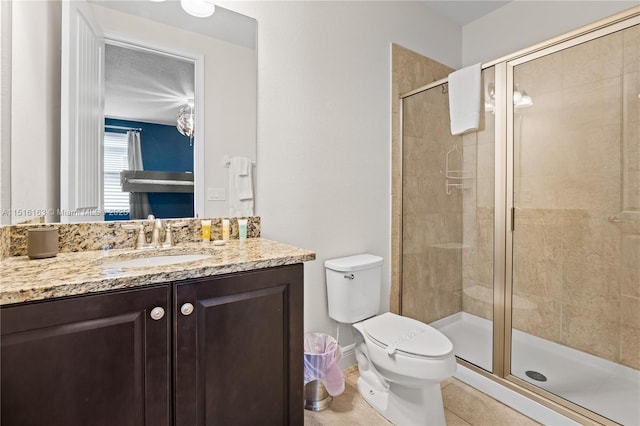 bathroom featuring vanity, toilet, an enclosed shower, and tile patterned flooring