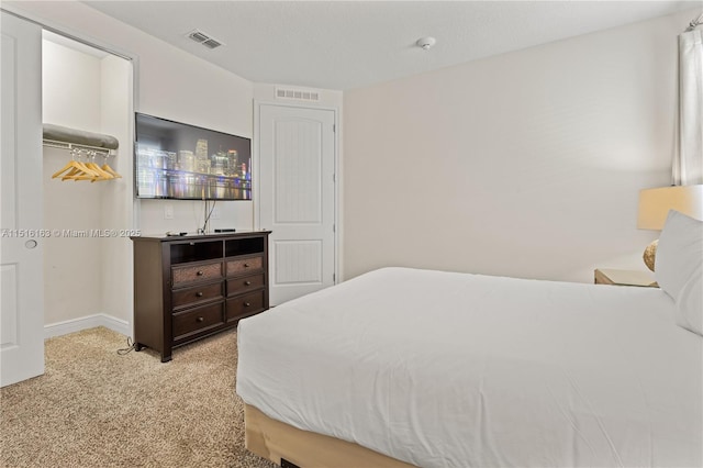 carpeted bedroom with a spacious closet and a closet