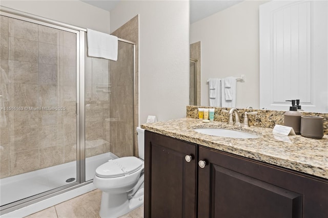 bathroom with vanity, toilet, tile patterned flooring, and a shower with door