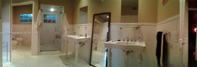 bathroom with a shower, toilet, sink, and tile flooring