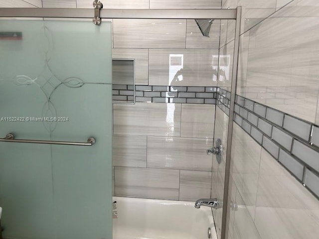 bathroom featuring combined bath / shower with glass door