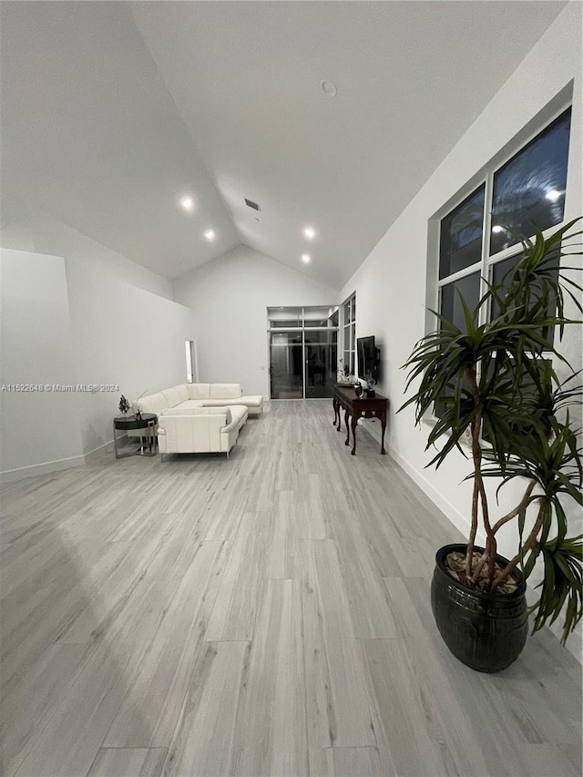 bedroom with vaulted ceiling and light wood-type flooring