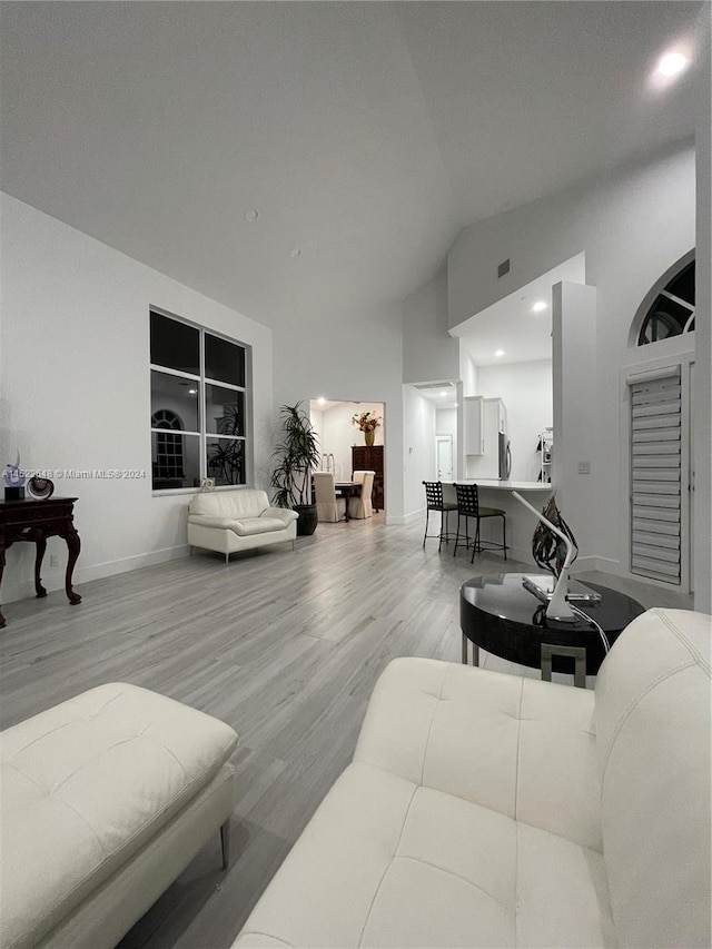 living room featuring vaulted ceiling and light hardwood / wood-style floors