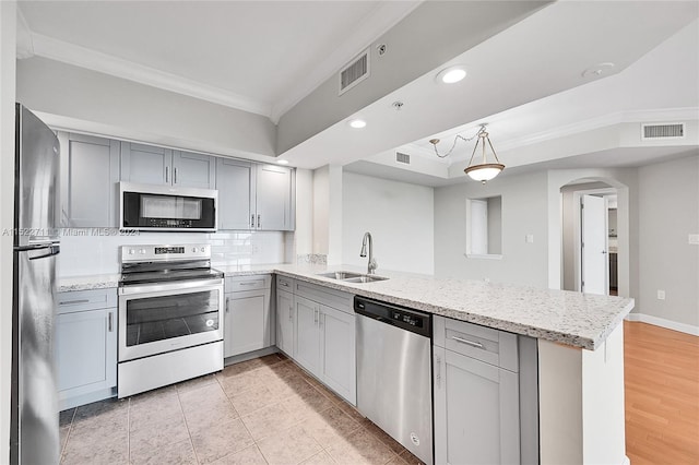 kitchen featuring gray cabinetry, crown molding, sink, appliances with stainless steel finishes, and kitchen peninsula