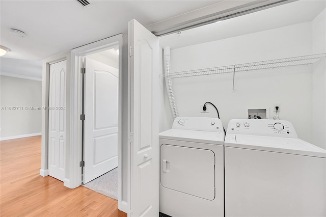 laundry room with hardwood / wood-style floors and washing machine and dryer