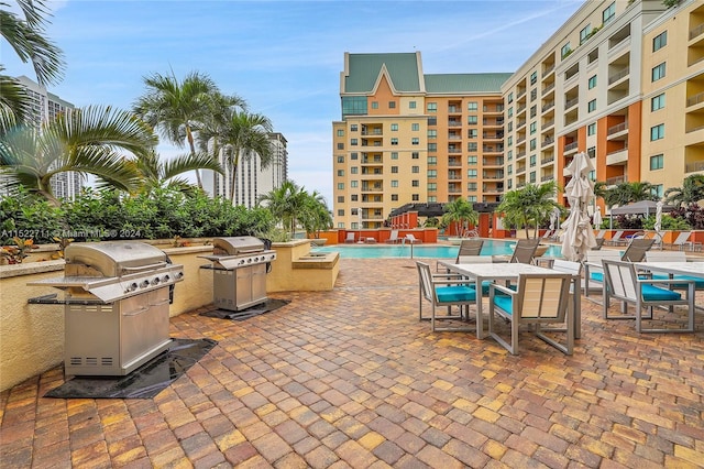 view of patio with area for grilling and a community pool