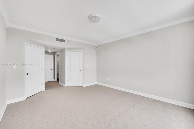 carpeted empty room featuring crown molding