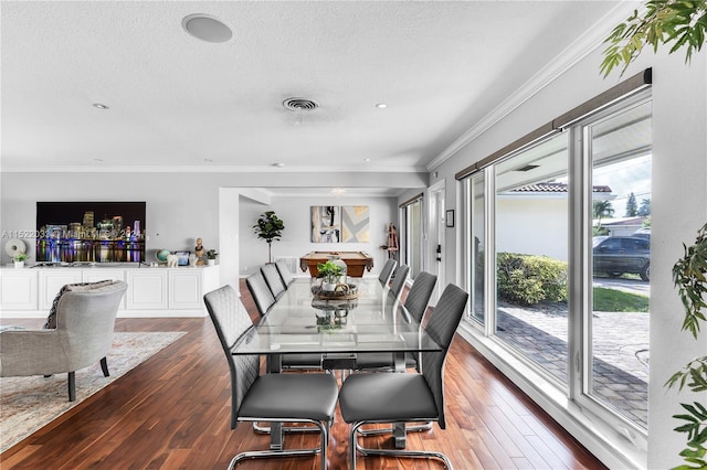 dining room featuring a textured ceiling, ornamental molding, and dark hardwood / wood-style floors