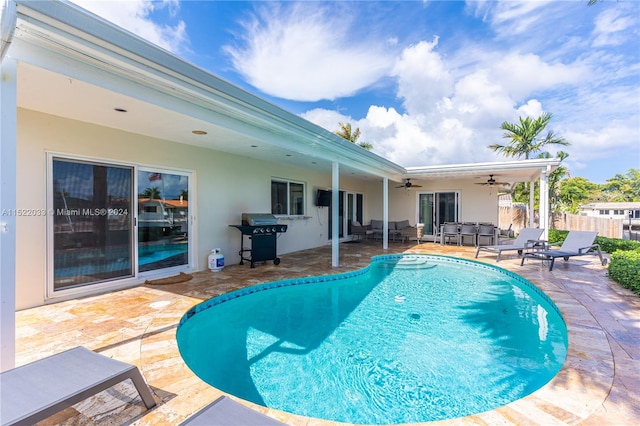 view of swimming pool with a patio area, area for grilling, and ceiling fan