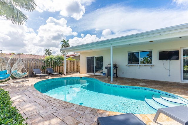 view of pool featuring grilling area and a patio