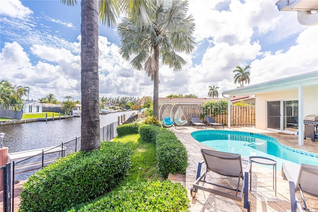 view of swimming pool featuring a water view and a patio