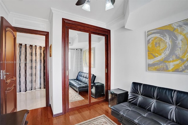 living room with ornamental molding, ceiling fan, and light hardwood / wood-style flooring