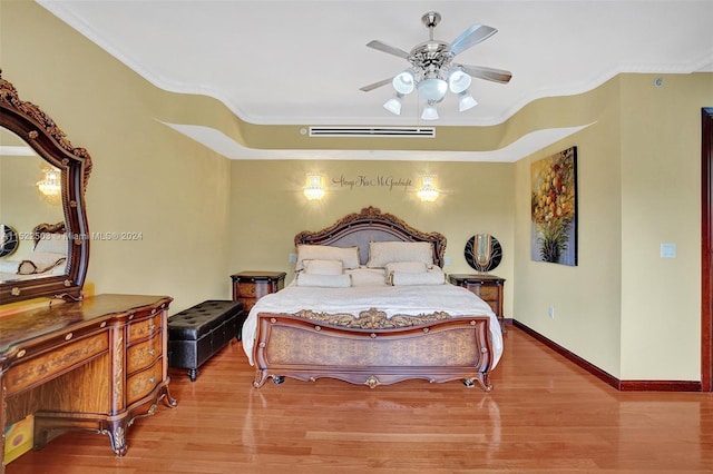 bedroom featuring crown molding, ceiling fan, and light wood-type flooring