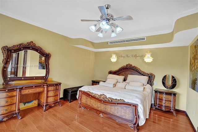 bedroom with crown molding, ceiling fan, and light hardwood / wood-style flooring