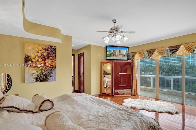 bedroom with access to exterior, hardwood / wood-style floors, and ceiling fan