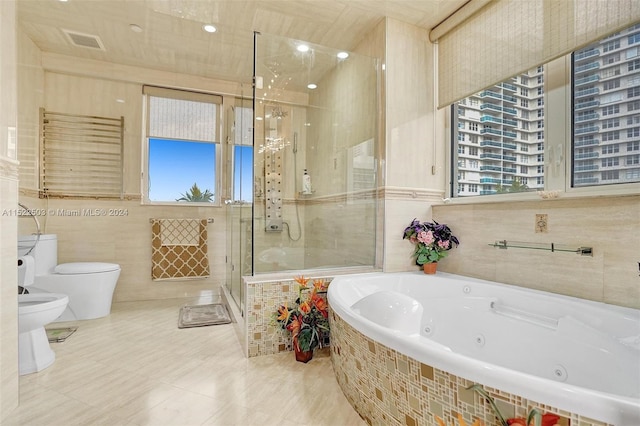 bathroom with tile walls, toilet, tile flooring, and a wealth of natural light