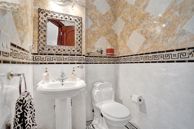 bathroom featuring tile walls, tile floors, and toilet