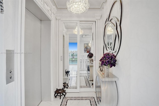 hallway with light tile floors, ornamental molding, and a notable chandelier