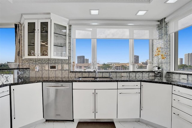 kitchen featuring backsplash, white cabinets, dark stone countertops, and stainless steel dishwasher