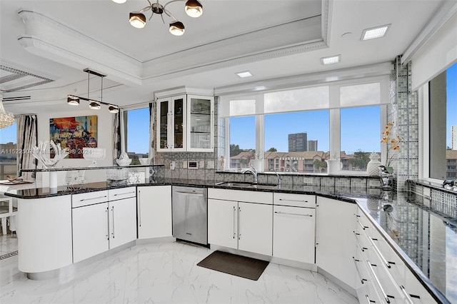 kitchen with white cabinetry, stainless steel dishwasher, backsplash, and pendant lighting