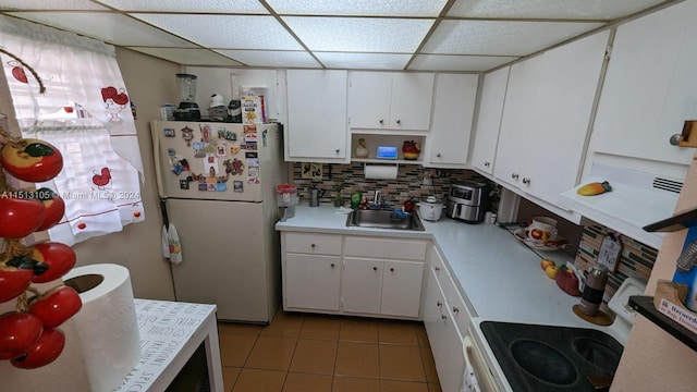 kitchen with white cabinets, sink, tasteful backsplash, and white fridge