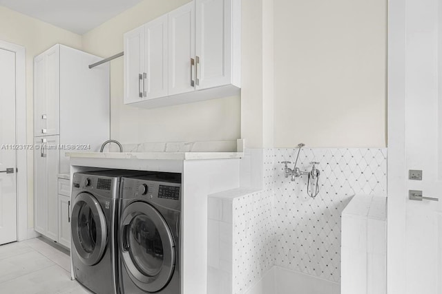 washroom featuring light tile floors and washer and clothes dryer