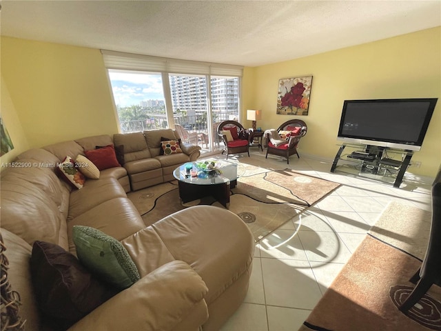 living room featuring light tile floors, floor to ceiling windows, and a textured ceiling