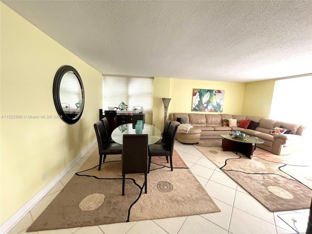 dining area featuring a textured ceiling and light tile floors