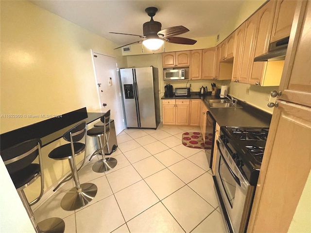 kitchen with stainless steel appliances, light tile flooring, ceiling fan, and sink