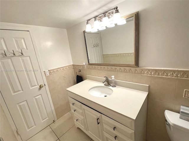 bathroom with toilet, vanity, tile walls, backsplash, and tile floors