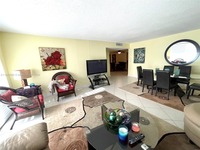 tiled living room featuring a textured ceiling