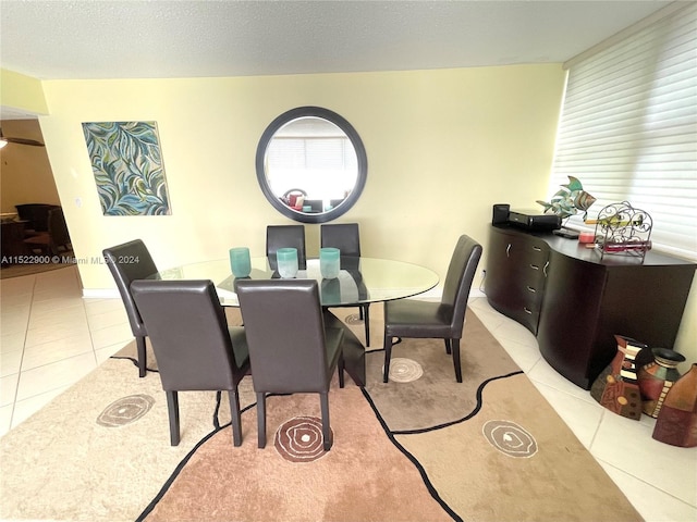 dining room featuring light tile floors and a textured ceiling