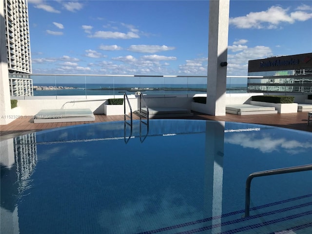 view of swimming pool featuring a water view