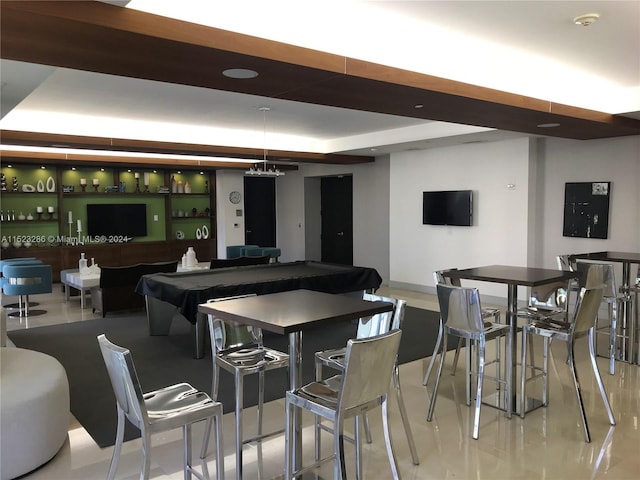 dining area featuring a tray ceiling and indoor bar