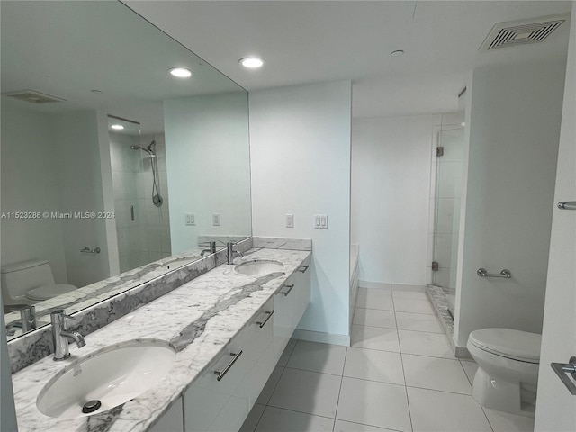 bathroom featuring toilet, dual bowl vanity, tile floors, and an enclosed shower