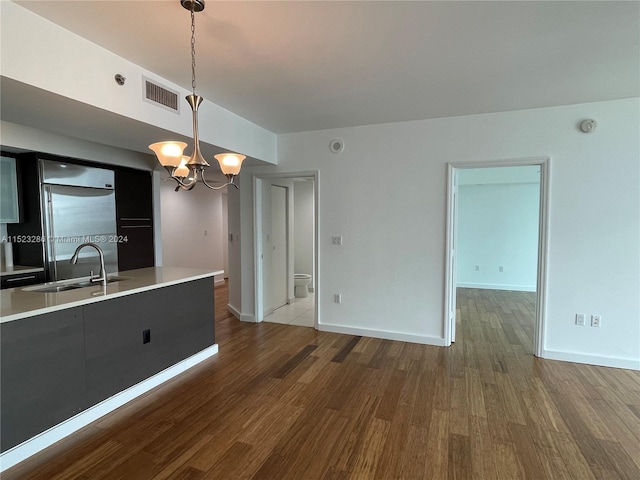 kitchen with hardwood / wood-style flooring, hanging light fixtures, an inviting chandelier, and sink