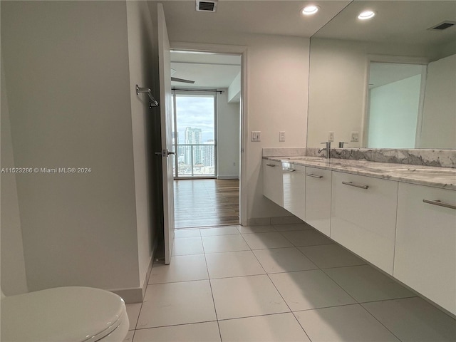 bathroom featuring oversized vanity, toilet, and tile flooring