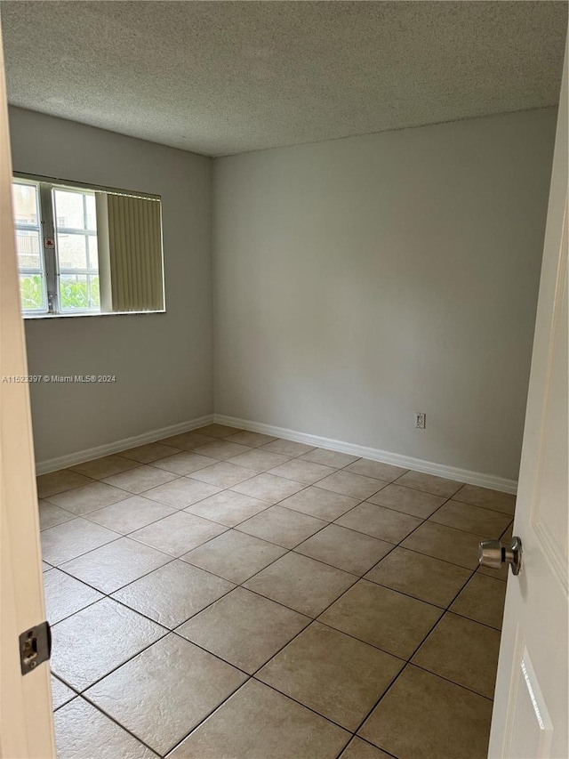 spare room with tile floors and a textured ceiling