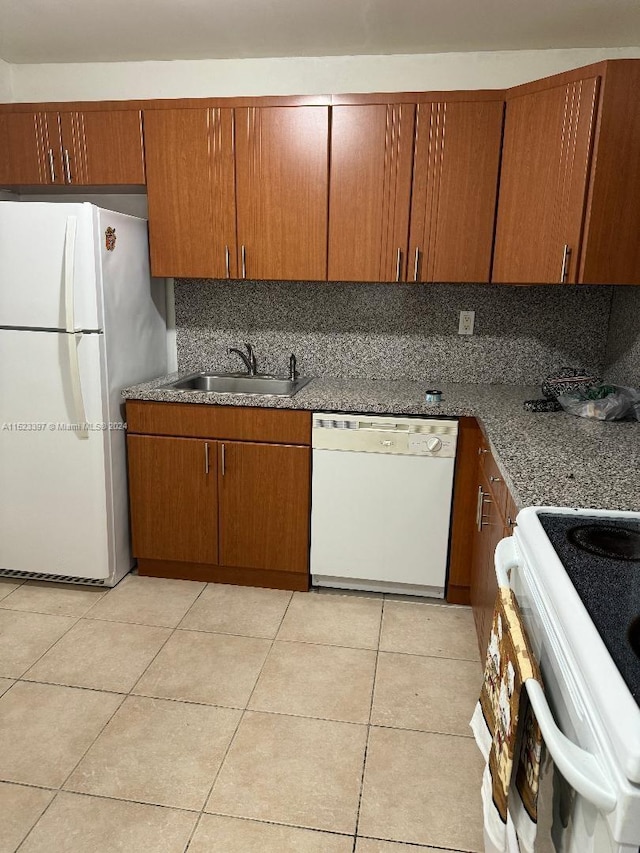 kitchen featuring backsplash, white appliances, sink, and light tile flooring