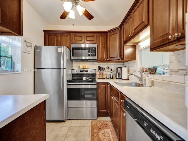 kitchen featuring backsplash, stainless steel appliances, ceiling fan, and sink