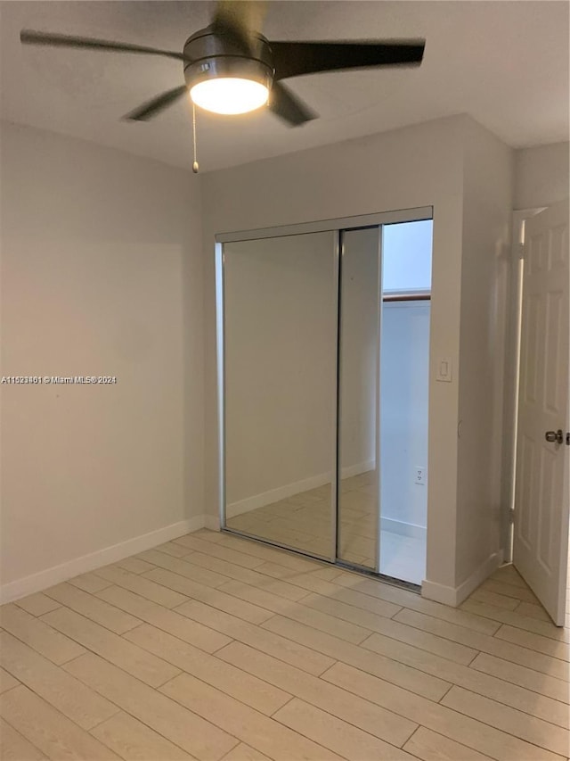 unfurnished bedroom with light hardwood / wood-style floors, a closet, and ceiling fan