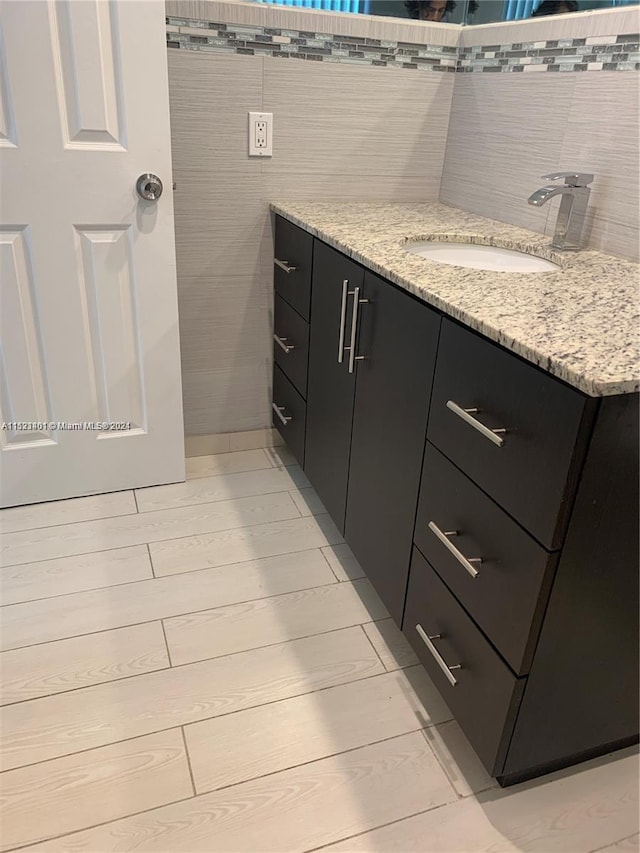 bathroom with vanity, tile floors, and tile walls