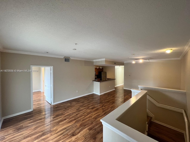 interior space featuring a textured ceiling, crown molding, and dark hardwood / wood-style floors