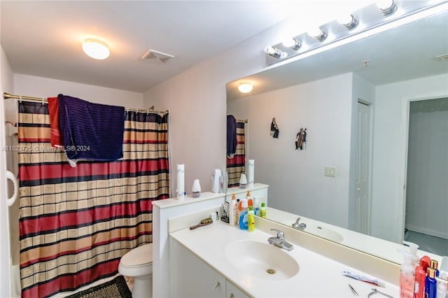 bathroom featuring toilet, vanity, and tile flooring