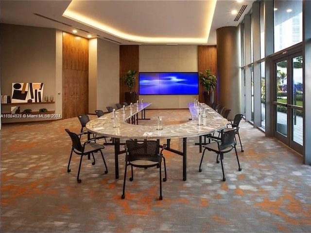 interior space featuring a raised ceiling, french doors, and light stone countertops