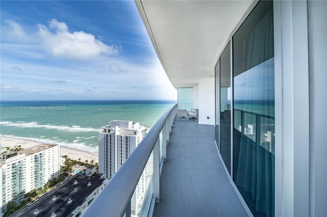 balcony featuring a water view and a view of the beach