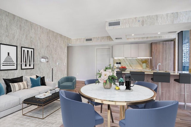 dining area with sink and light hardwood / wood-style flooring