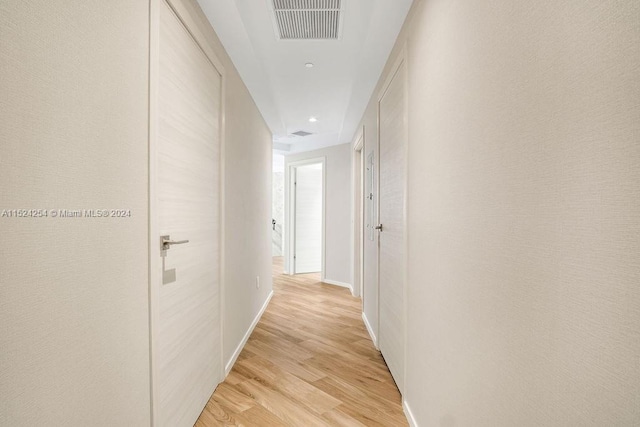 hallway with light hardwood / wood-style floors