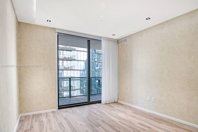 empty room with expansive windows and light wood-type flooring