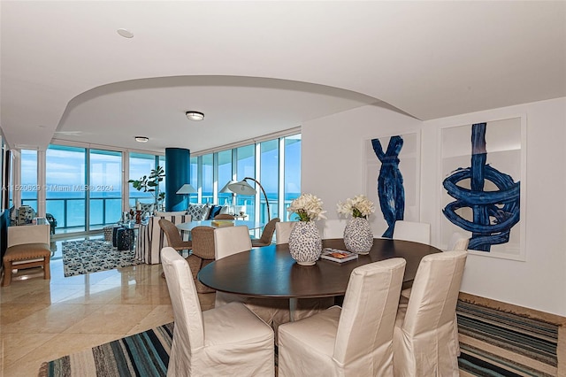 tiled dining area featuring a water view and a healthy amount of sunlight